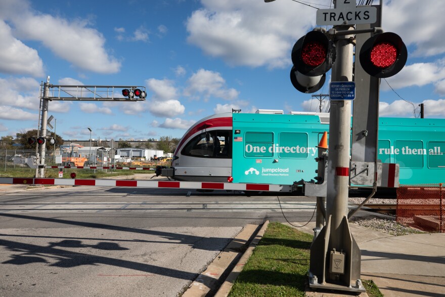 A MetroRail train passing Kramer Lane with the crossing gate down