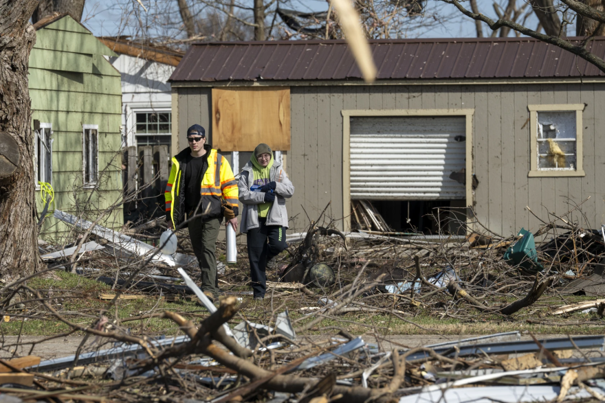People survey the damage after a tornado ravaged a residential neighborhood in Aroma Park, Ill., in March 2026.