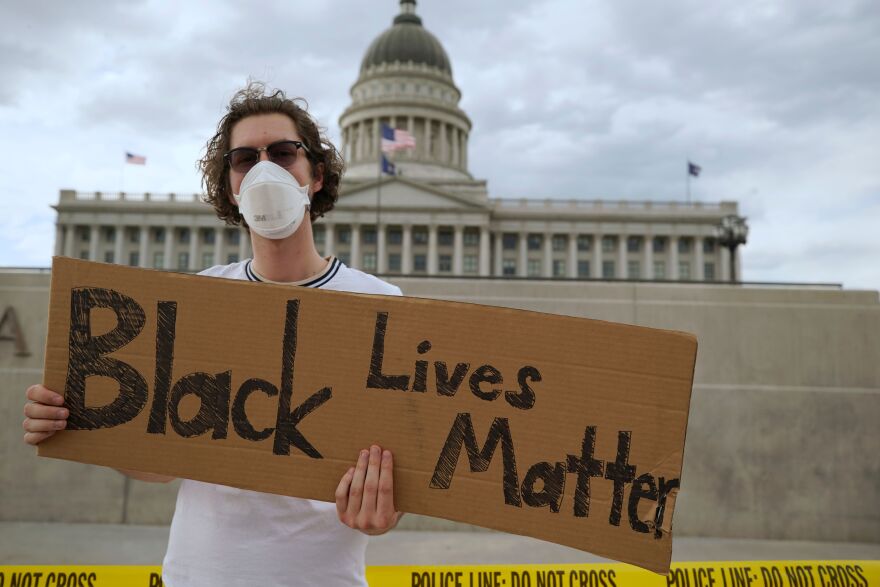A protester holds a sign in front of the Utah State Capitol building during a protest in Salt Lake City on June 5.