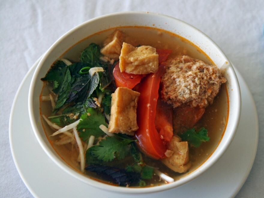 Linh Nguyen's Vietnamese soup features fried tofu, tomatoes, a scattering of fresh herbs and some delicate poached crab and pork dumplings.