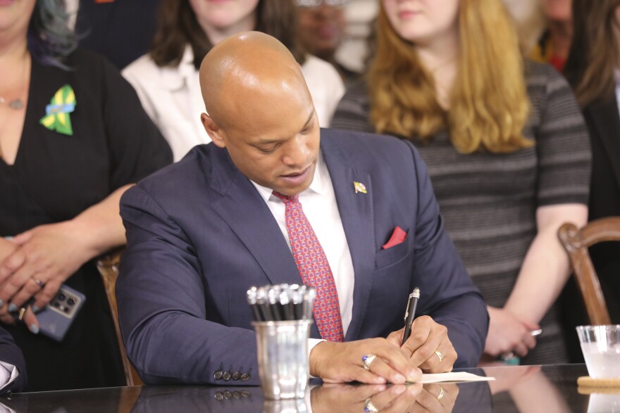 Maryland Gov. Wes Moore signs one of several gun-control measures during a bill-signing ceremony on Tuesday, May 16, 2023, in Annapolis, Md. One of the bills signed by the governor generally prohibits a person from wearing, carrying or transporting a gun into areas like schools or health care facilities. (AP Photo/Brian Witte)