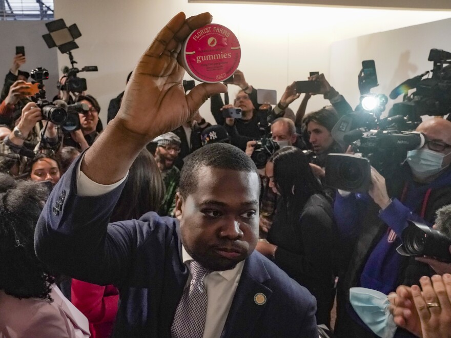 Chris Alexander, center, executive director of New York State Office of Cannabis Management, shows off the first purchase of cannabis gummies bought at Housing Works—New York's first legal cannabis dispensary, during a press conference to kick-off its opening, Thursday Dec. 29, 2022, in New York.