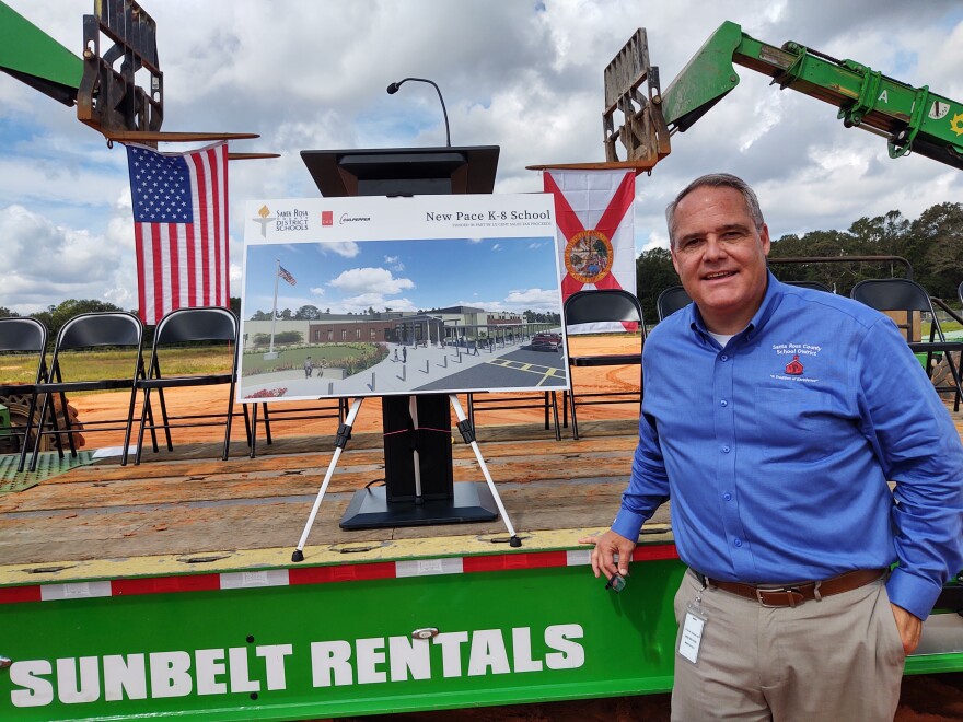 Joey Harrell, Santa Rosa's assistant superintendent for administrative services, stands near a rendering of what the new Pace K-8 will look like.