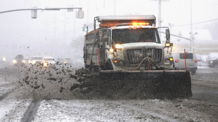 A snowplow clears a street as snow fall hampers the morning commute Friday, Jan. 17, 2020, in Salt Lake City. The storm dropped up to five inches (13 centimeters) within about four hours, said National Weather Service meteorologist Charlotte Dewey. In the mountains, some places saw more than a foot of snow. (AP Photo/Rick Bowmer)
