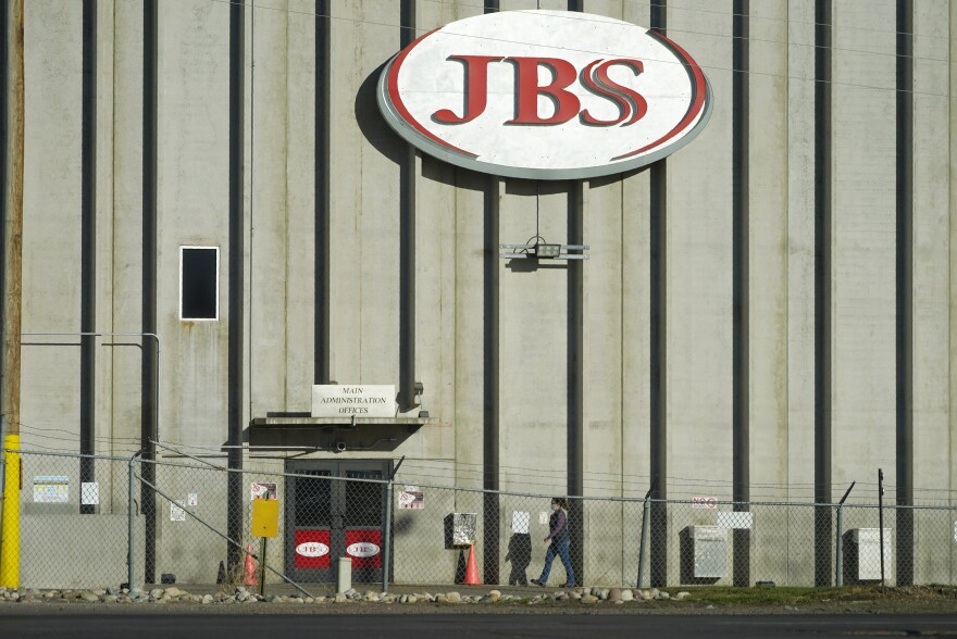 FILE - A worker heads into the JBS meatpacking plant in Greeley, Colo., on Oct. 12, 2020. Packers Sanitation Services Inc., or PSSI, one of the country's largest food safety cleaning service providers employed more than 100 children as young as 13 in dangerous jobs at 13 meat processing plants in eight states, including JBS, the U.S. Department of Labor said Friday, Feb. 17, 2023.