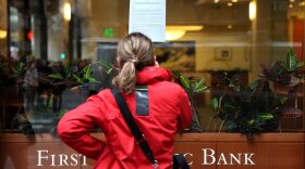 A passerby in San Francisco stops on Monday to read a posted announcement from the FDIC about the seizure of First Republic Bank and sale to JPMorgan Chase.