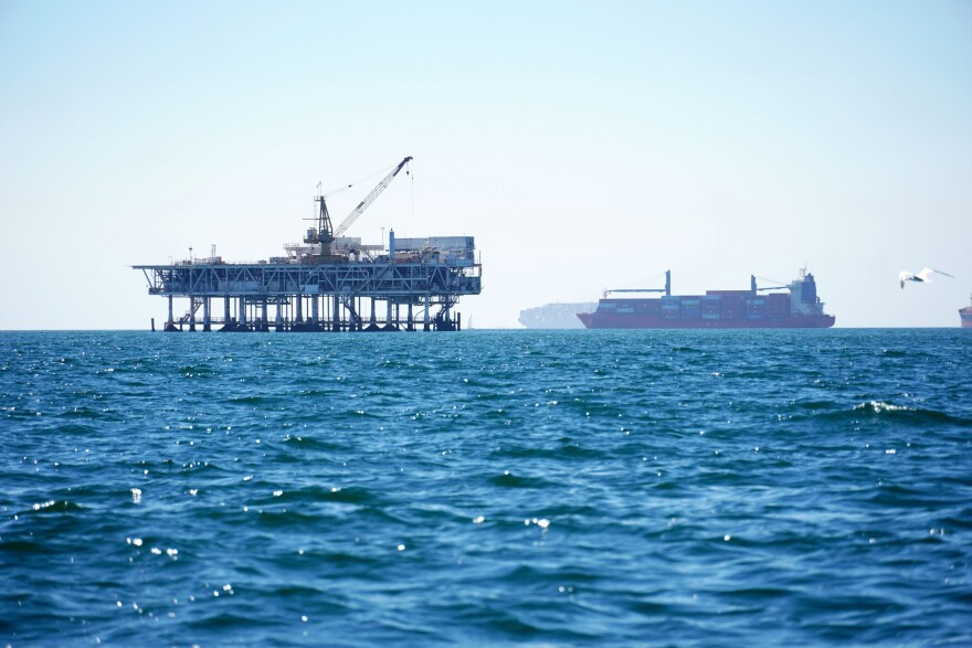 FILE - In this Tuesday, Oct. 5, 2021 file photo, dozens of cargo vessels are anchored offshore, sharing space with about a half dozen oil platforms, before heading into the Los Angeles-Long Beach port. 