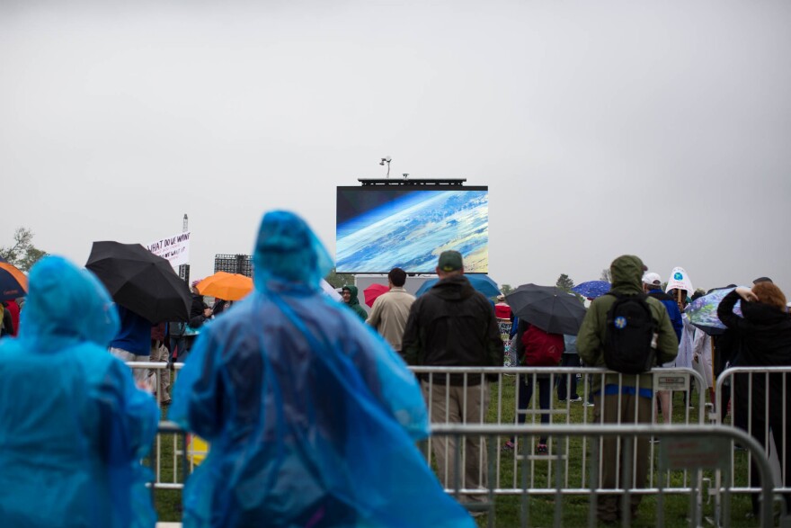 People gather to watch a presentation during the rally near the Washington Monument.