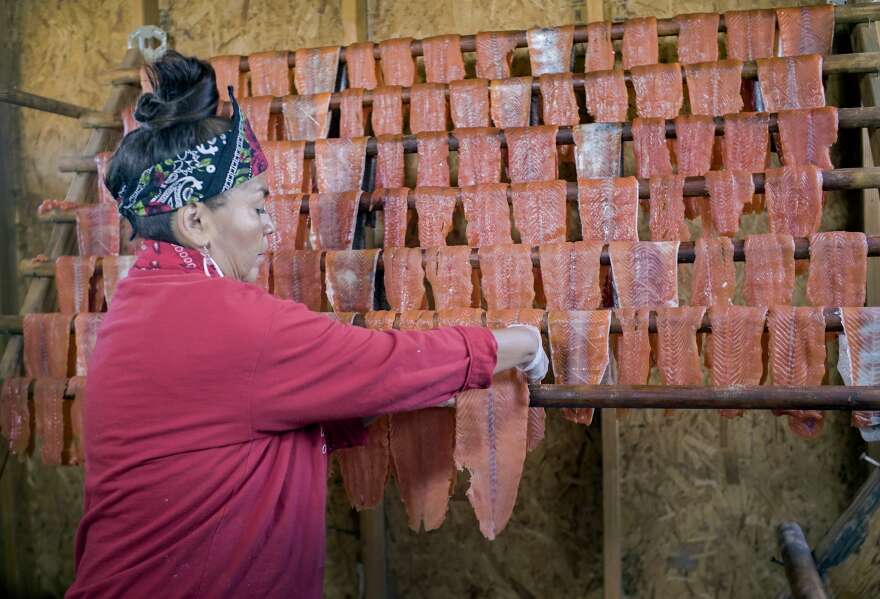 Brigette McConville of the Confederated Tribes of Warm Springs, prepares wind-dried salmon the traditional way in September 2021. The head and bones are removed and the salmon is then sliced into strips, salted and hung to dry for several days. 