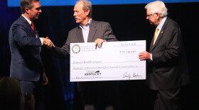 Gov. Andy Beshear (left) and U.S. Rep. Hal Rogers (right), present a check to Lonnie Lawson, director of the Center for Rural Development.