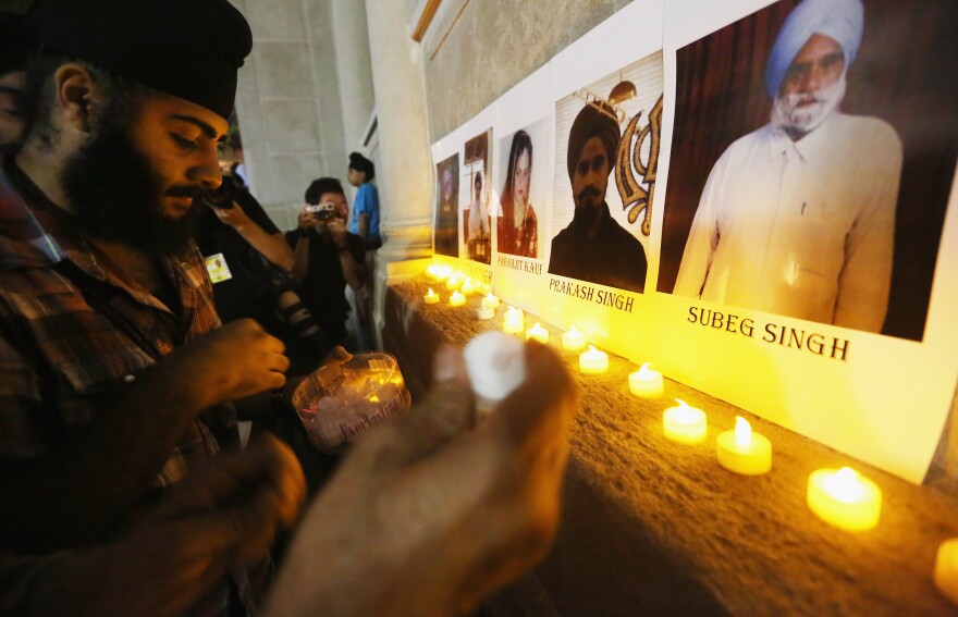 Photos of victims are seen during a candlelight vigil in Union Square for victims of the Wisconsin Sikh temple shooting on August.