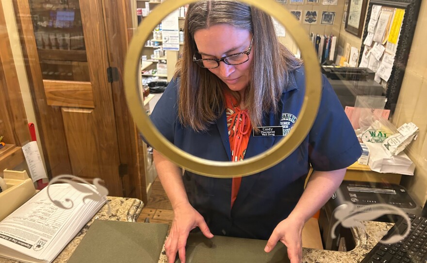 Pharmacist Cindy Dinger says her corner of the store would struggle without the rest of Wall Drug. “All this stuff around us — the poster and print shop, the boot shop, the fudge shop, the café — they pay our bills," she says. (Arielle Zionts/KFF Health News)