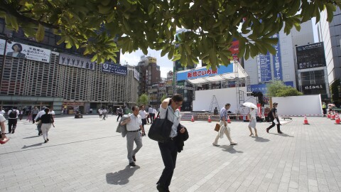 People make their way in the scorching heat at a business district in Tokyo, Monday, July 23, 2018.