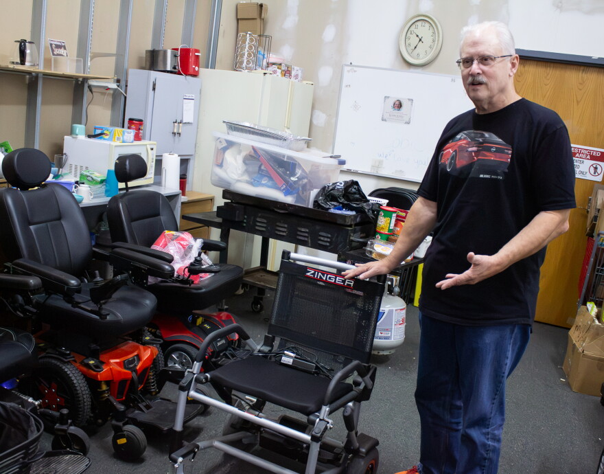 Doug Griswold pictured with powered chairs at the Wichita Medical Loan Closet.