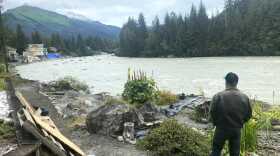 a person stands on the bank of a river