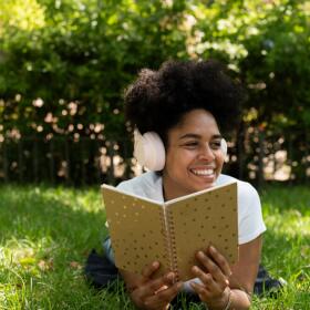 A woman listens to an audiobook with headphones. (Getty Images)
