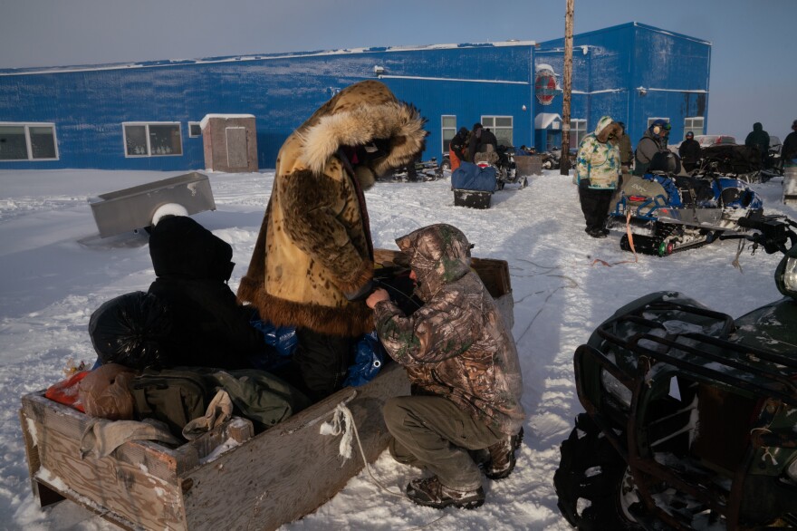 Members of Nelson Island School's basketball team prepare to travel by snow machine-pulled wooden sleds to an away game at a neighboring village.