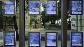Digital signs advertising homes for sale adorn the window of a London Foster realty office, in Kendall, Fla., Thursday, Oct. 19, 2023. The long-standing real estate commission structure is under legal scrutiny in several courts.