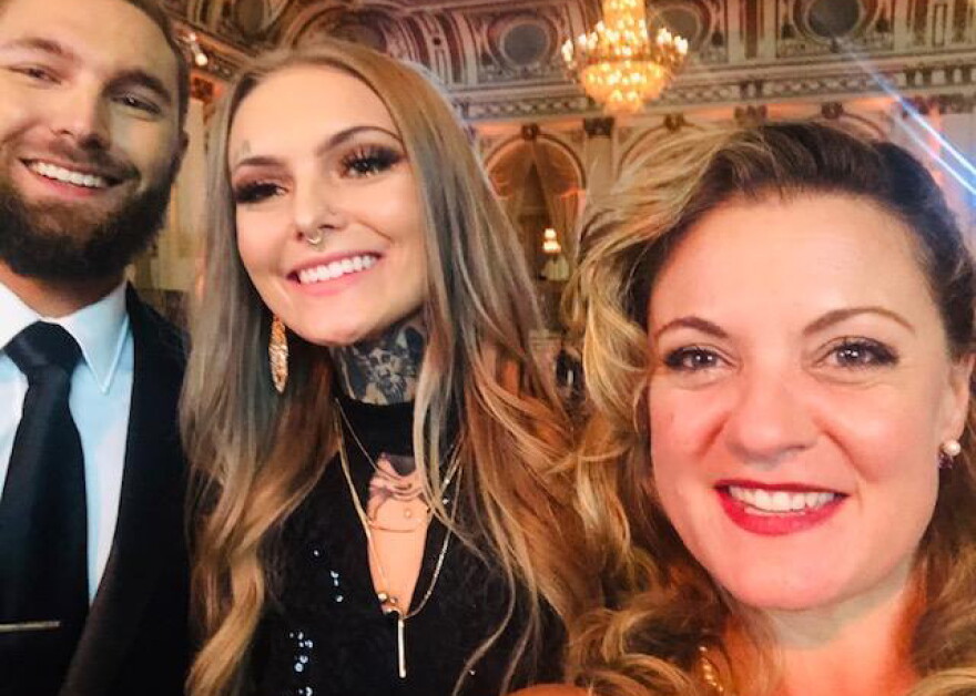 Three people smile into the camera 