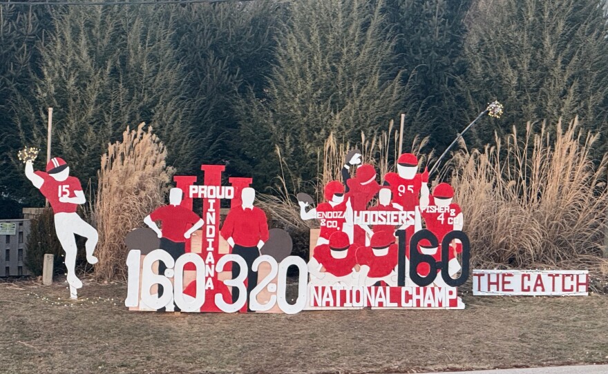 Wooden cutouts showing support for Indiana University line a street near Memorial Stadium on Tuesday, Jan. 20, 2026, in Bloomington, Ind.