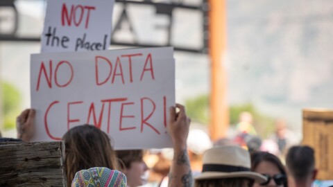 A protester waves a "No Data Center" sign outside of a special meeting of the Box Elder County Commission at the BEC Fairgrounds in Tremonton, May 4, 2026.