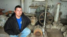 Justin Johnston crouching by sludge pump