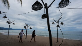 People walk on the beach after the passing of Hurricane Simon in Puerto Vallarta, Mexico, Monday, Oct. 12, 2026.
