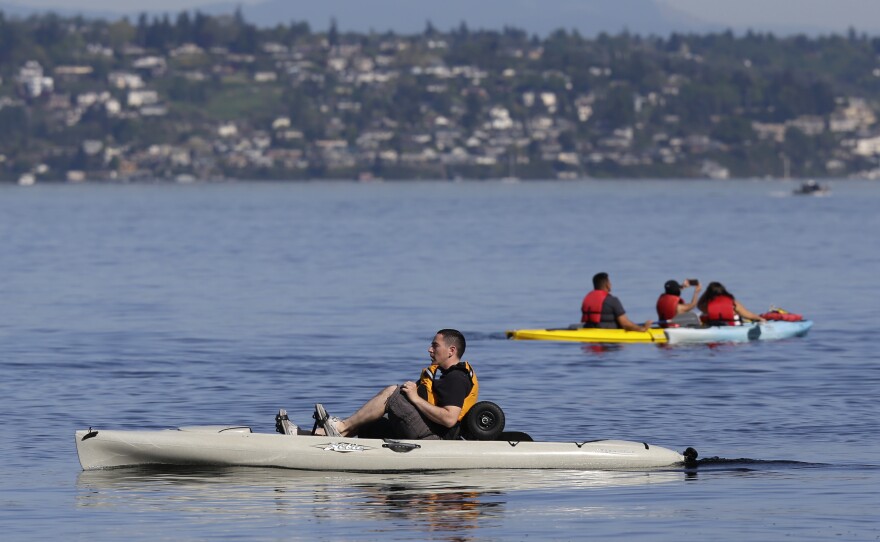 A kayaker in a pedal kayak, left, moves past a more traditional craft near Owen Beach in Point Defiance Park, Monday, April 18, 2016, in Tacoma, Wash. 