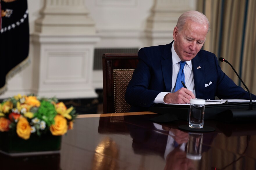 President Biden takes notes during a meeting to discuss clean energy efforts with CEOs of U.S. electric utility companies at the White House in February 2022. [Anna Moneymaker/Getty Images]