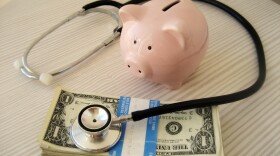 piggy bank, stethescope, and bundle of money