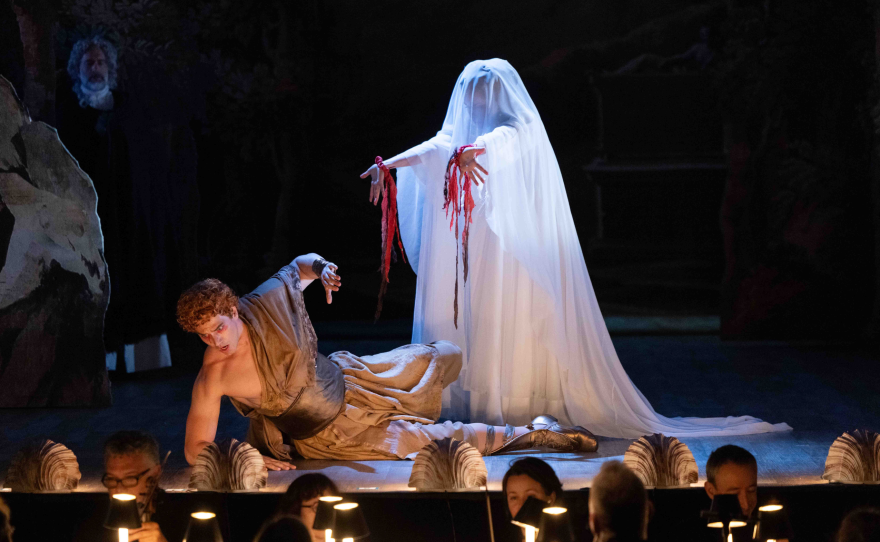 Octavia, dressed in a white sheet with red ribbons pouring from her wrists, towers over a terrified Nero.