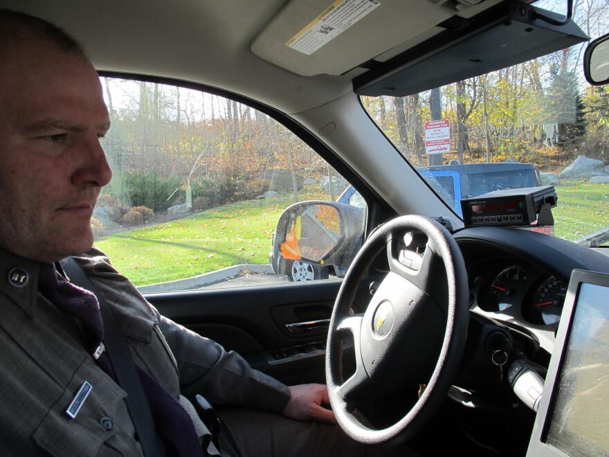 New York State Trooper Clayton Howell checks a screen that displays driving records inside his patrol SUV. The vehicle allows him to see whether passing drivers are on their phones. "It's a bird's-eye view," he says.