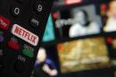 The Netflix button on a television remote control is juxtaposed with a Netflix web page. (Richard Drew/AP)