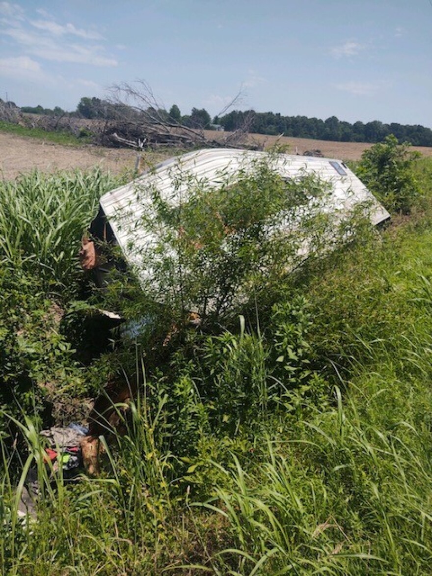 An abandoned camper in tall grass