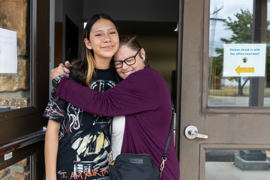 Former Daposka Teacher Tina Burruss Townley hugs Wahreshe Hamilton outside of the recently closed school on Aug. 17.