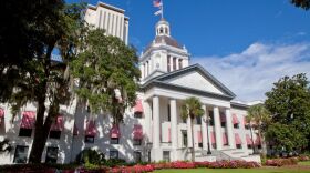 A white Capitol building with trees to the left and right