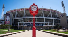 A red pedestal with a four-faced clock on top.