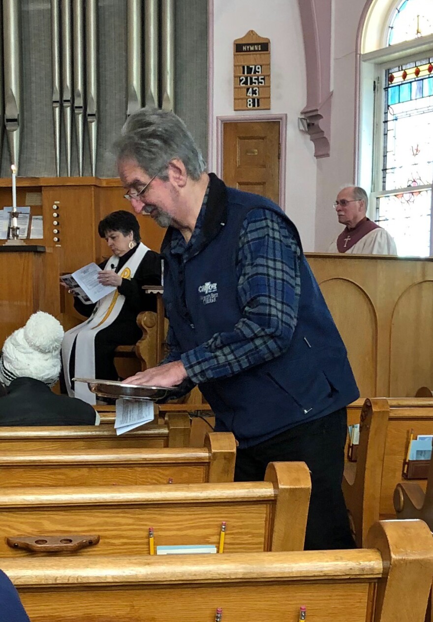 Ray Tascarella passes the collection plate at the United Community Church.