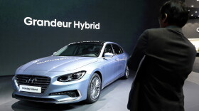 A man takes a photo of Hyundai Motor's Grandeur Hybrid vehicle during a media preview of the 2017 Seoul Motor Show in Goyang, South Korea, Thursday, March 30, 2017.