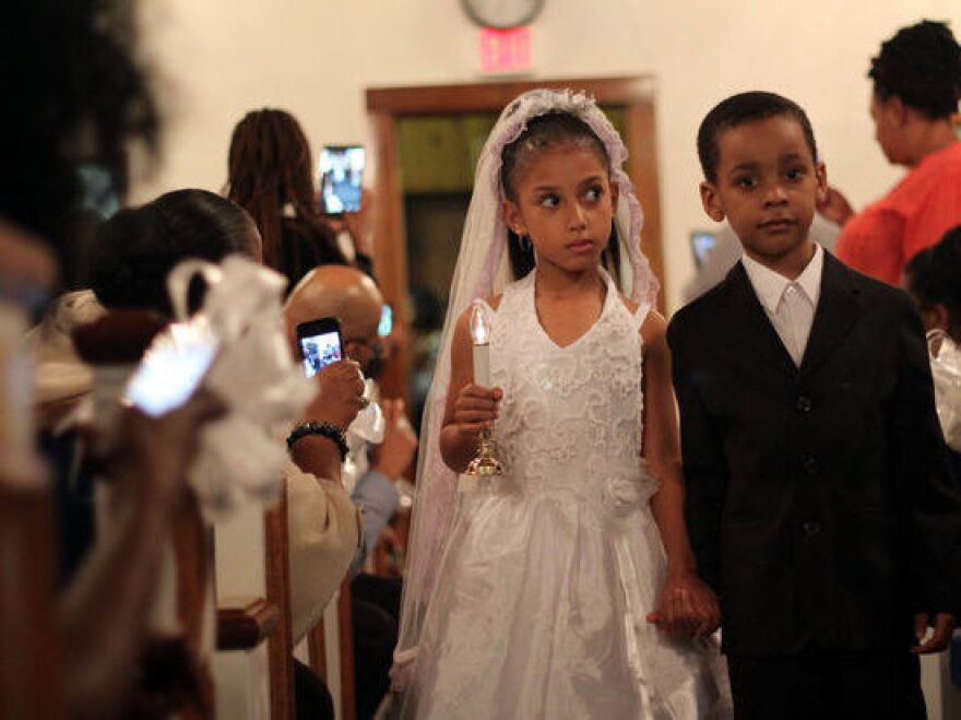 A young couple walks down the aisle in a recent Tom Thumb wedding on Staten Island.