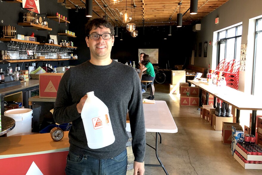 Jeff Wulsich holds a bottle of the hand santizer they are now producing and bottling in their distillery.