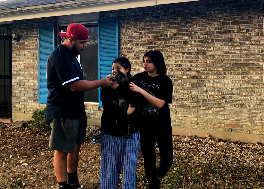 Jesse, Jessette and Jesseña Yebra pet Jessette's cat, Prince Valiant, outside their home in North East San Antonio. Jessette adopted the cat during the pandemic.