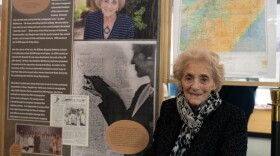 Bea Shaheen McPherson sits next to the Military Mapping Maidens exhibit at the MAPS Air Museum in Green featuring her story of drawing maps by hand for World War II.