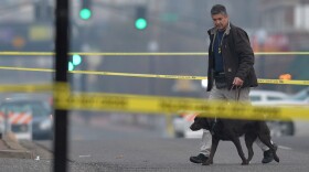 An agent with the Department of Alcohol Tobacco and Firearms arrives on the crime scene outside the Ferguson Police Department on Thursday. Just down the road, community leaders and residents have been struggling to digest this latest shock.