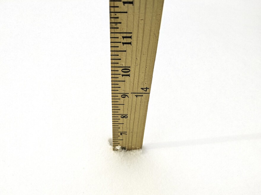 A ruler stood up in the snow measuring six inches deep