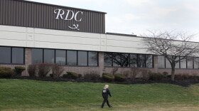 A woman in a security uniform walks the grounds of Rochester Drug Cooperative in Chili Tuesday afternoon after the company announced it will no longer distribute controlled substances.