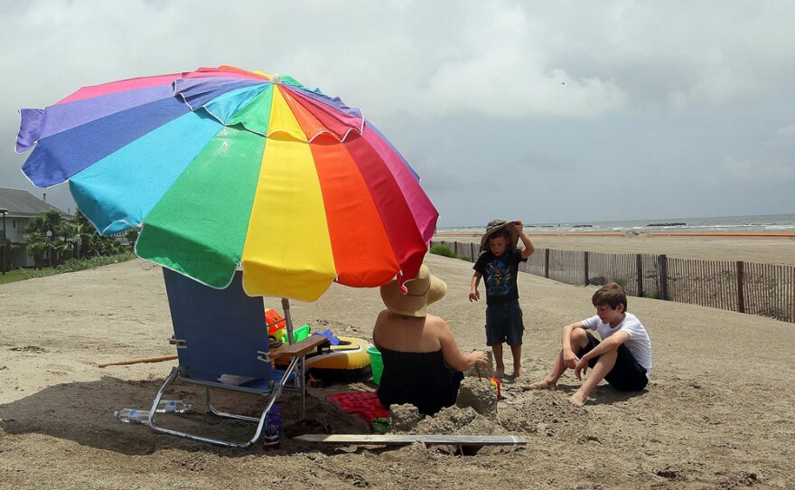 With her sons James (center) and Benny, Millie Eichler sits behind a fence prohibiting people from using the public beach because of oil coming ashore in Grand Isle, La.