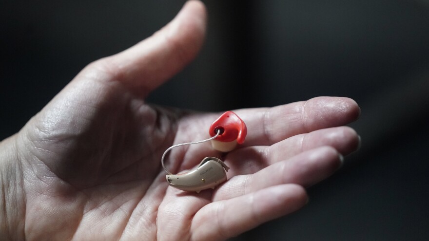 Chelle Wyatt holds her hearing aid Friday, April 15, 2022, in Salt Lake City. (AP Photo/Rick Bowmer)