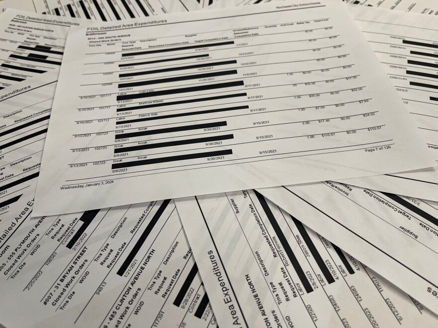 A sample of some of the Rochester City School District's response to an open records request seeking work orders for restroom repairs as schools with each page showing heavy redactions with detail blacked out.