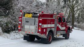 A fire truck with chains on the tires is on a snowy street